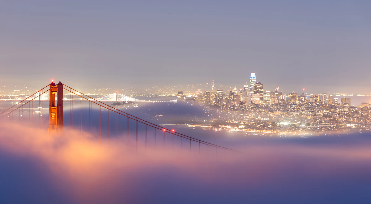 The San Francisco skyline rising above the fog at night